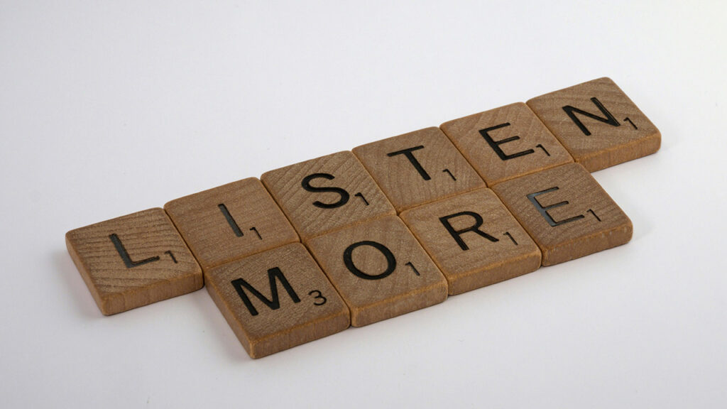 Image of Scrabble tiles lined up to say "Listen More"